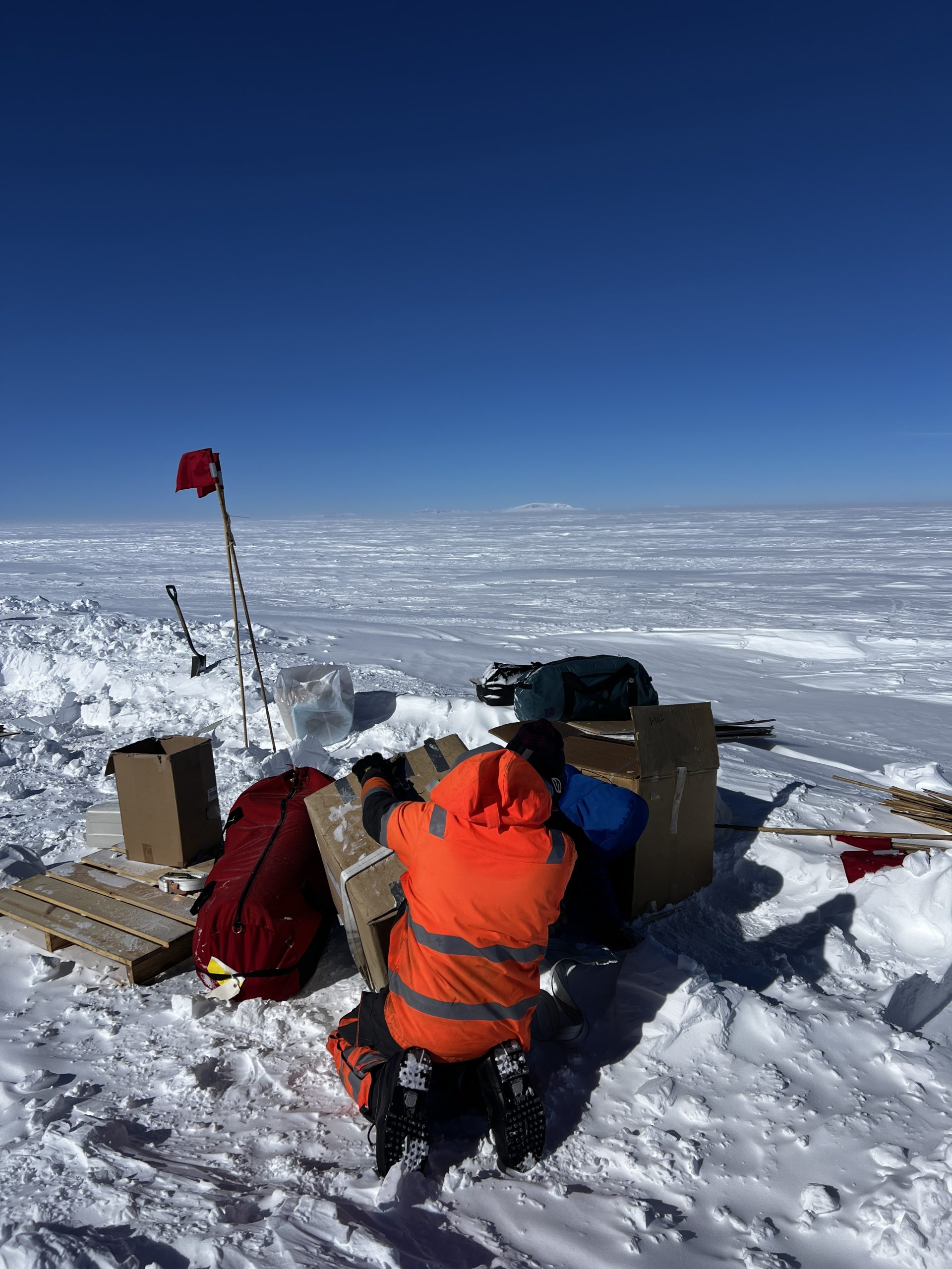 Elliot in his Orange Man suit, sorting through cargo